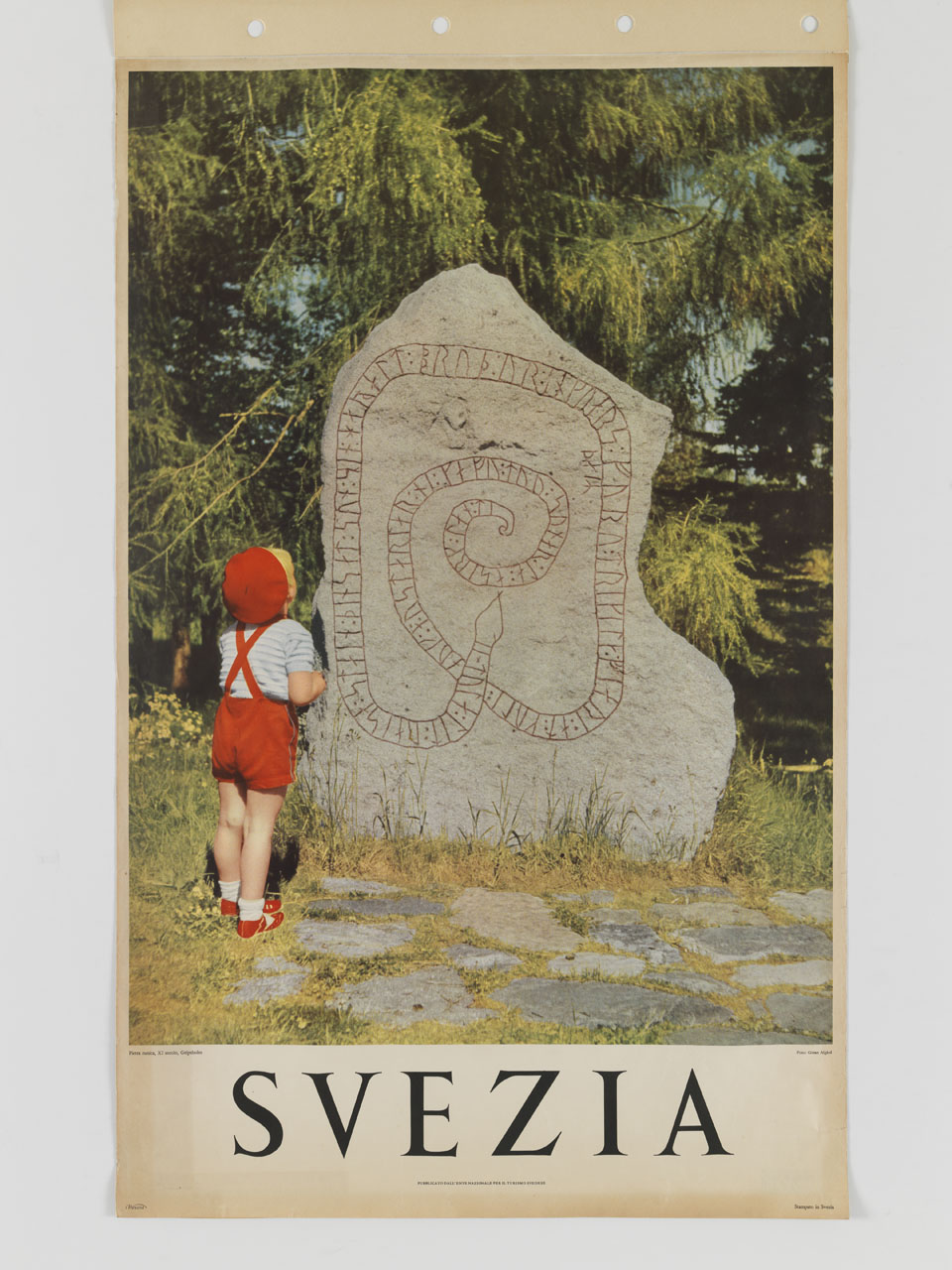 ritratto fotografico di un bambino di spalle che osserva una pietra runica (manifesto) - ambito svedese (terzo quarto sec. XX)