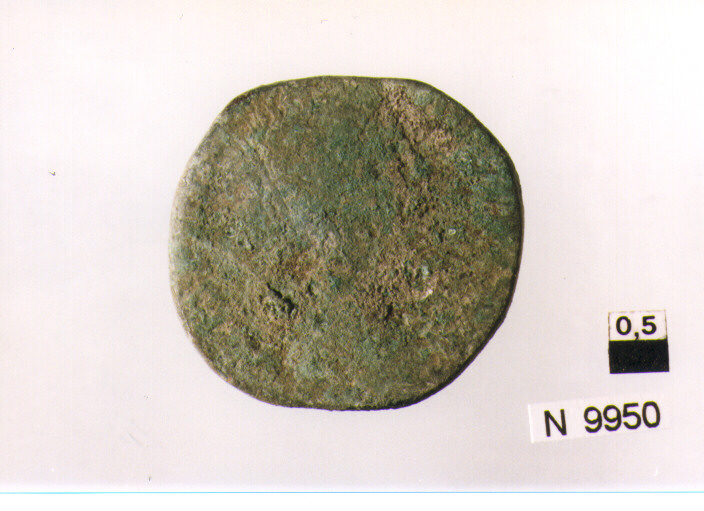 R/ illeggibile; V/ Sole stante a destra con la testa volta a sinistra, tiene il globo nella amno sinistra, la destra sollevata, ai suoi piedi un prigioniero (moneta, follis) (sec. IV d.C)