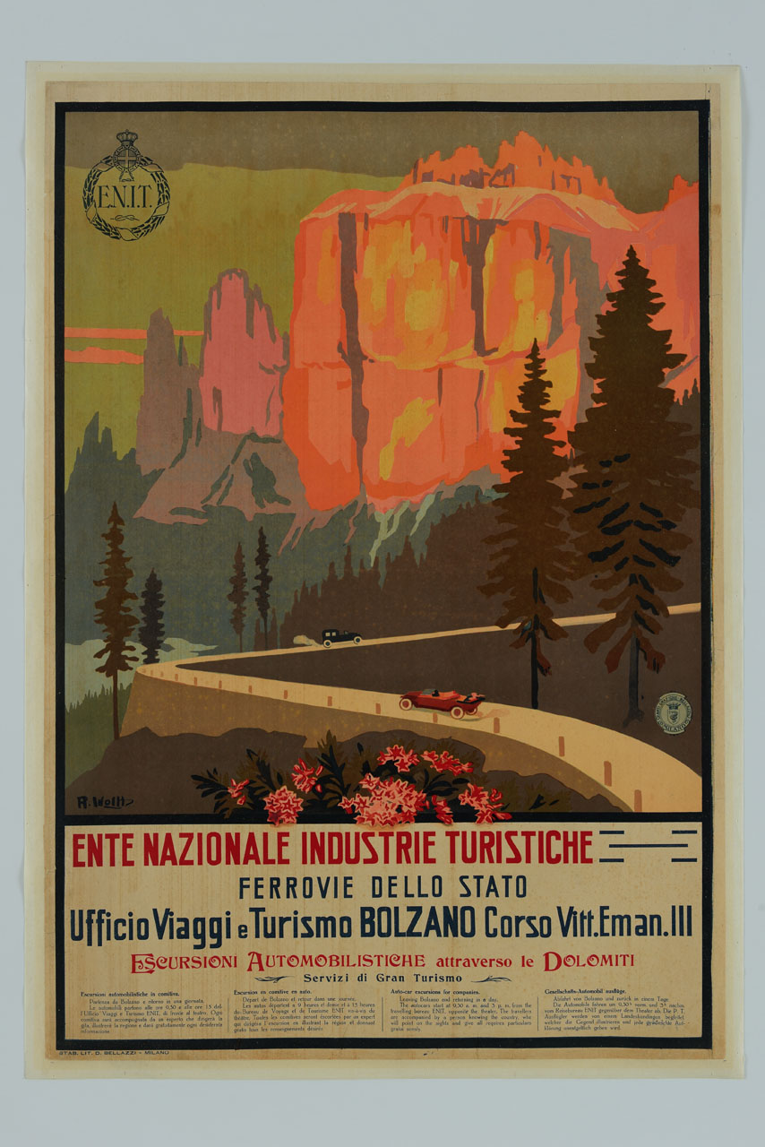 due vetture percorrono tornanti di una strada panoramica delle Dolomiti, sullo sfondo picchi montani (manifesto) di Wolf Remo (sec. XX)