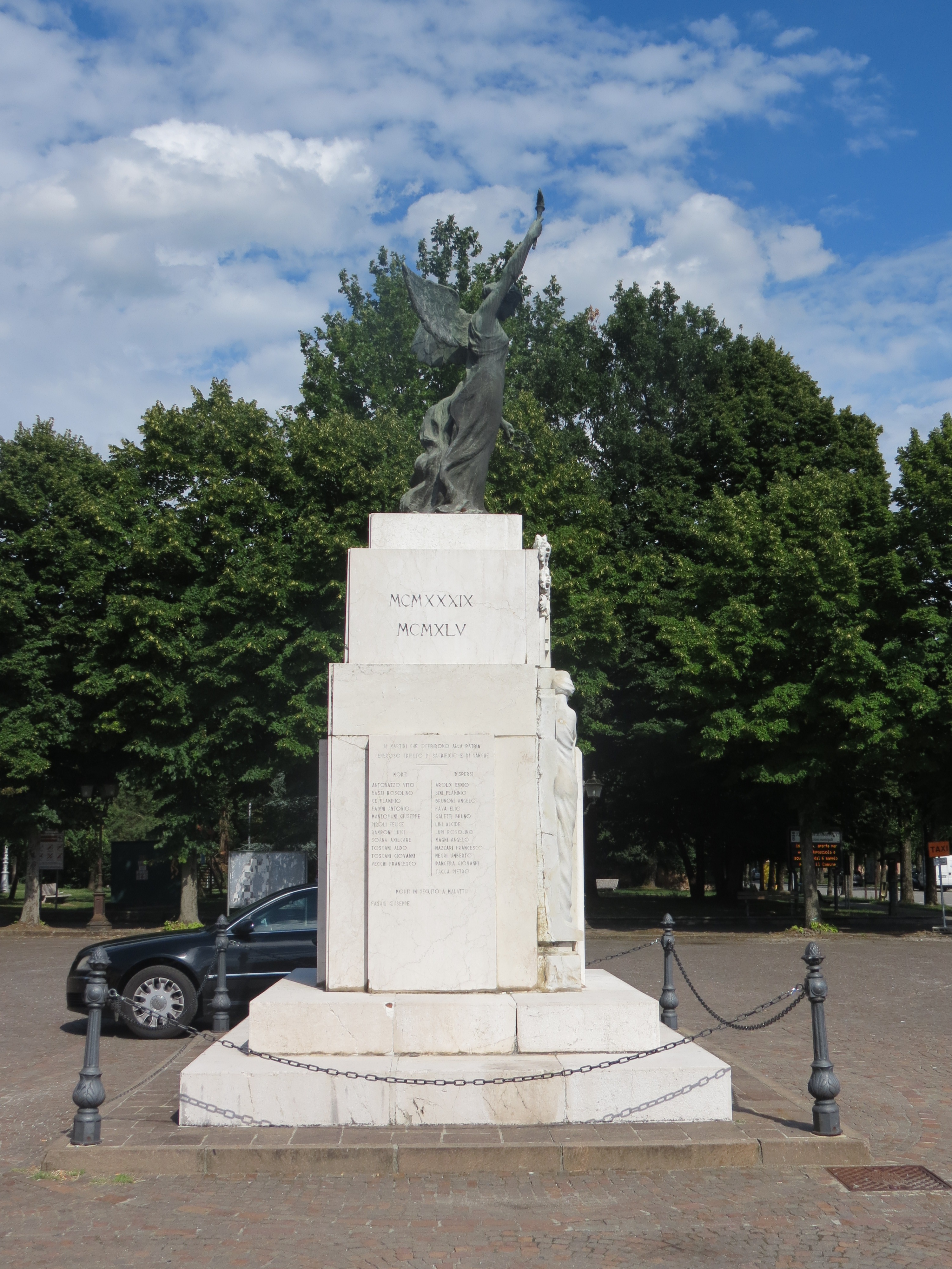 allegoria della Vittoria come donna vestita all'antica con una fiaccola e una corona di alloro (statua in bronzo), figura femminile con foglie di alloro e figura maschile con una mazza (rilievo sul lato frontale del cippo) (monumento ai caduti - a cippo) di Balestreri Aldo (sec. XX, sec. XX)