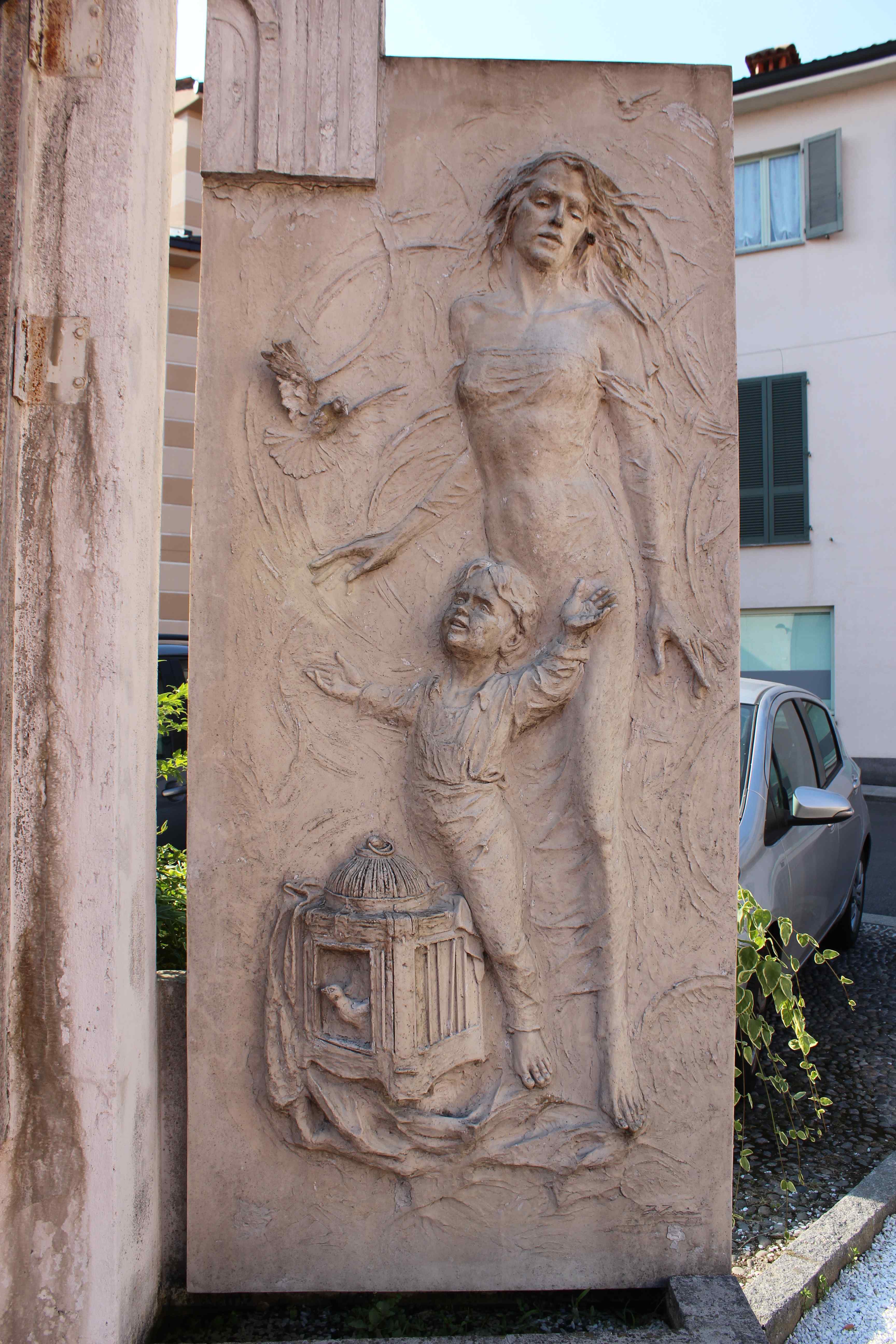 Madre con bambino che libera un uccellino dalla gabbia (monumento ai caduti - a stele, opera isolata) - ambito italiano (prima metà sec. XX)