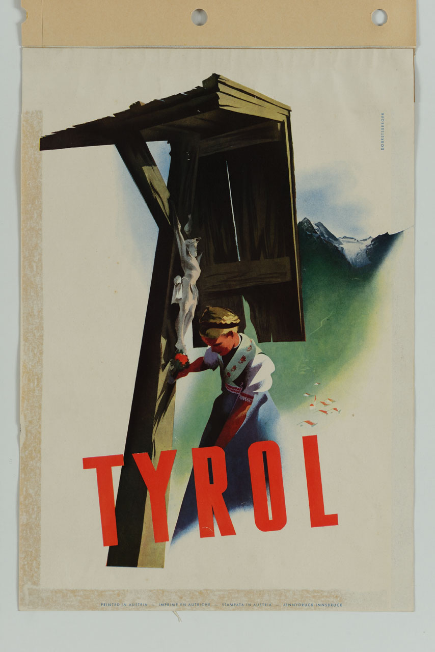 una ragazza con abito tirolese porta dei fiori ad un crociffisso viario; sullo sfondo un paese a valle di alcune montagne (manifesto) di Dobretsberger Fritz (sec. XX)