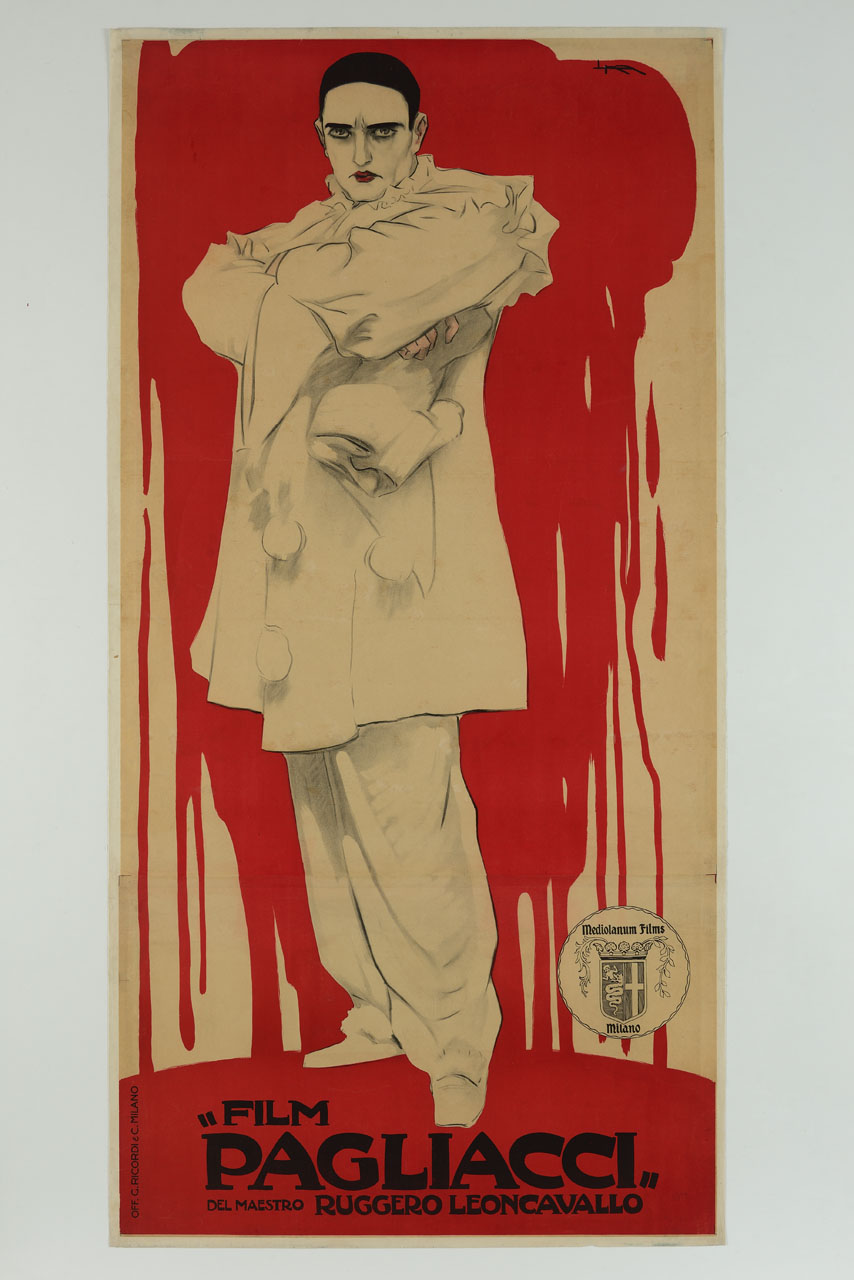 il protagonista Canio in abito da pagliaccio in piedi a braccia conserte con sguardo pieno di vendetta, posto su uno sfondo di sangue rosso, che colando, forma una pozza su cui poggia (manifesto) di Metlicovitz Leopoldo (sec. XX)