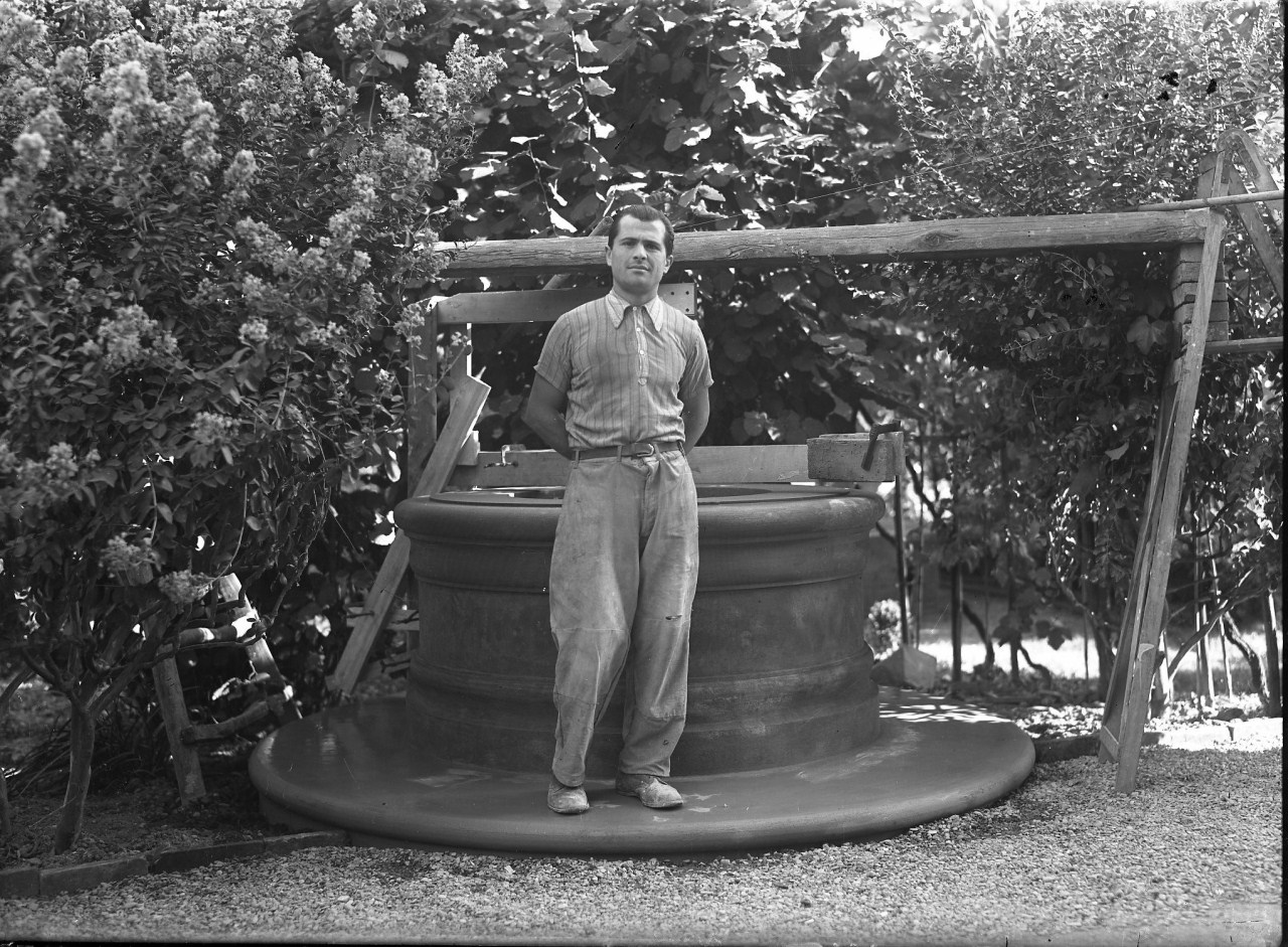 Ritratto di uomo accanto a un pozzo in giardino (negativo) di Anonimo (prima metà XX)