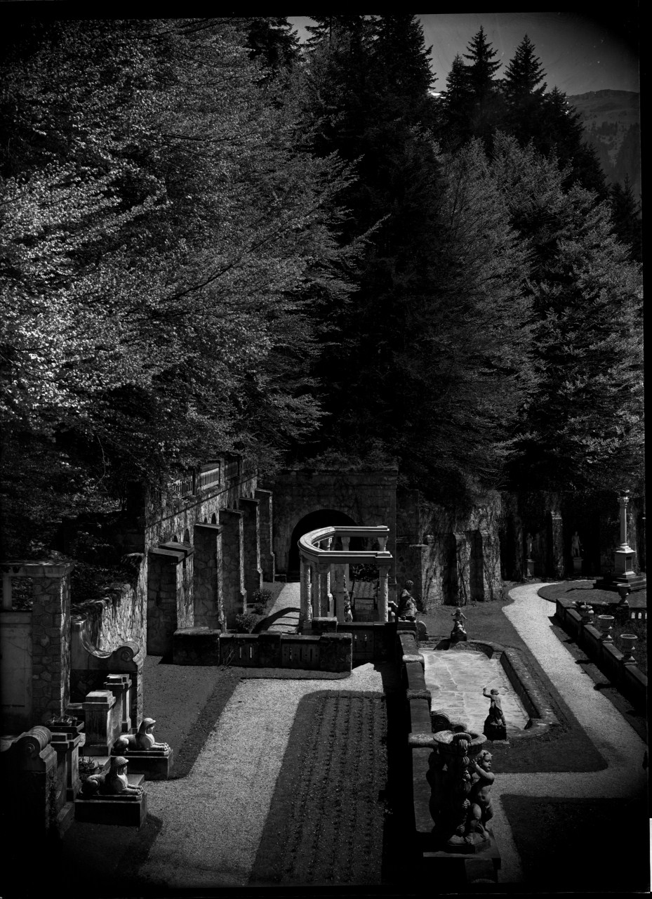 Parco di una villa in contesto alpino; particolare delle terrazze con vasca, esedra, aiuole appena piantate e sfingi decorative (negativo) di Anonimo (prima metà XX)