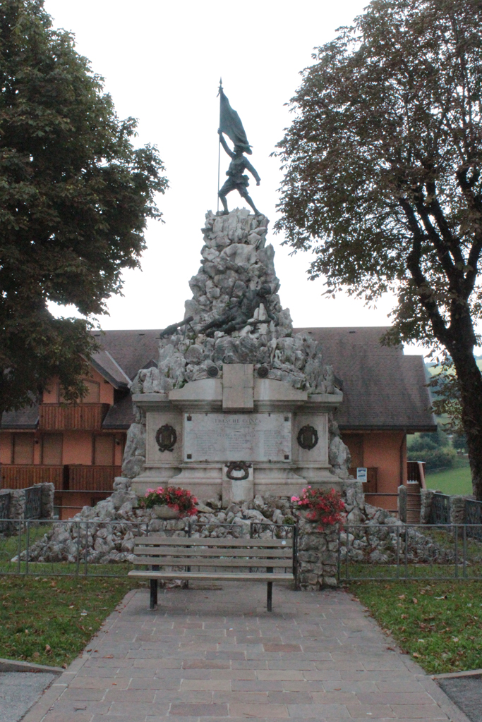 figura di soldato: alpino che porta la bandiera, morte del soldato (monumento ai caduti - a cippo) di Caldana Egisto (sec. XX, sec. XX)