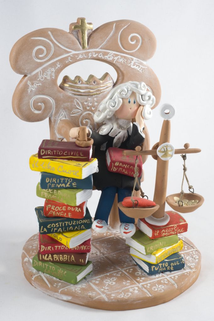 Un giudice arbitro in terra del bene e del male?, giudice con bilancia e libri (fischietto, a fessura interna, strumenti musicali) di Capasso Patrizia (ceramista) - laboratorio (2011)