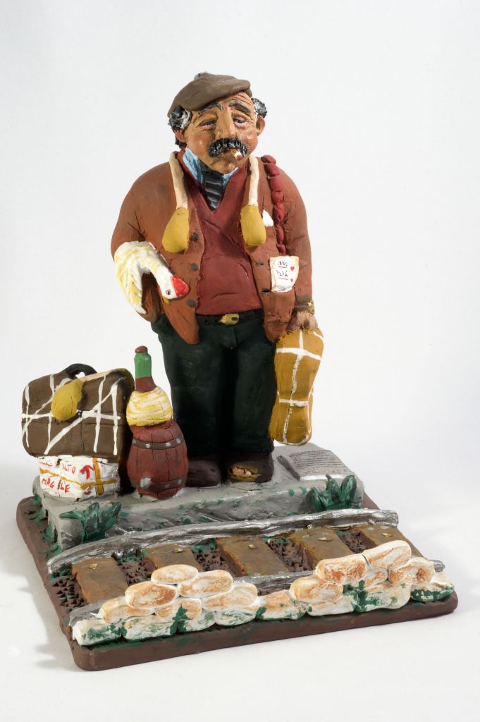 L’emigrand, figura maschile con borsa (fischietto, a fessura interna, strumenti musicali) di Gasparro Vito Lorenzo - laboratorio (2003)