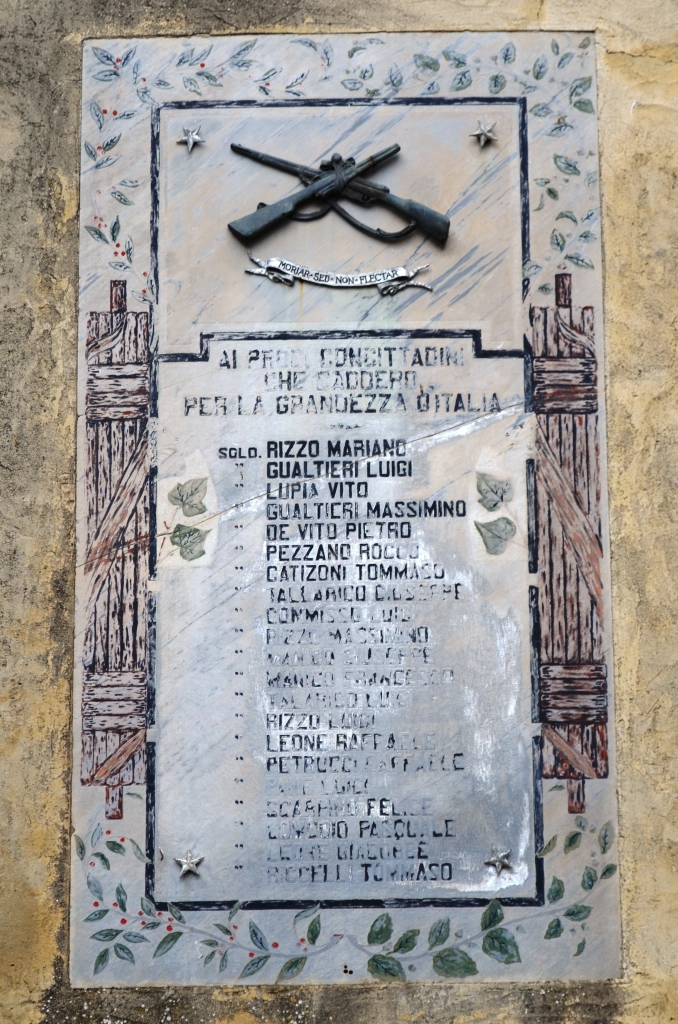 elementi decorativi con fucili incrociati, decorazioni a cornice con fasci littori (lapide commemorativa ai caduti) - ambito Italia meridionale (prima metà XX)