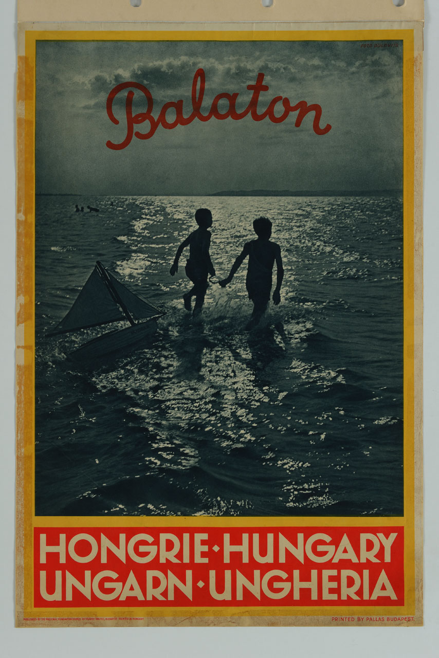 due bimbi al lago Balaton corrono in acqua lasciandosi alle spalle un modellino di barca a vela (manifesto) di Dulovits - ambito ungherese (metà sec. XX)