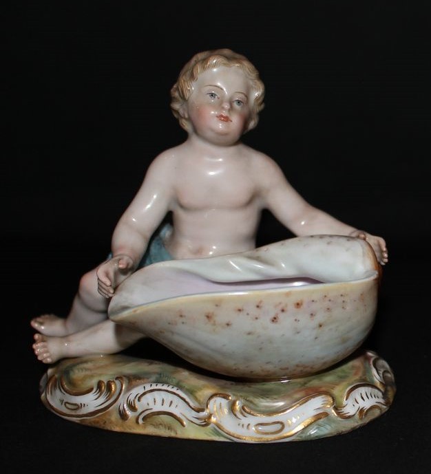 fanciullo seduta su base rocaille con una conchiglia (Volutidae-Cymbium cymbium) (saliera) di Porzellan-Manufaktur Meissen - manifattura di Meissen (secc. XIX-XX)