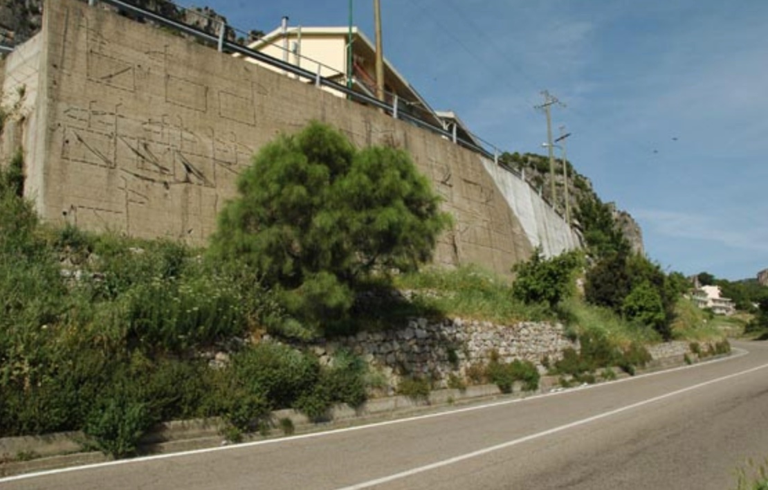 Le capre cucite, intervento artistico su muro di contenimento a bordo strada (installazione ambientale) di Maria Lai - Land Art (XX secolo, seconda metà)