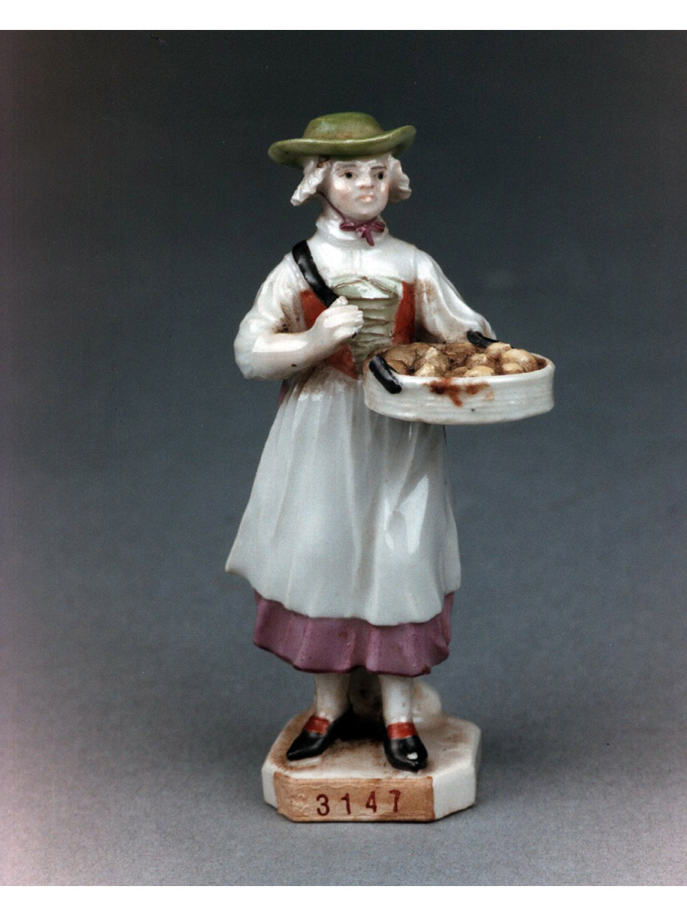 mendicante con gerla colma di legna (statuetta) - manifattura di Fuerstenberg (secc. XVIII/ XIX)