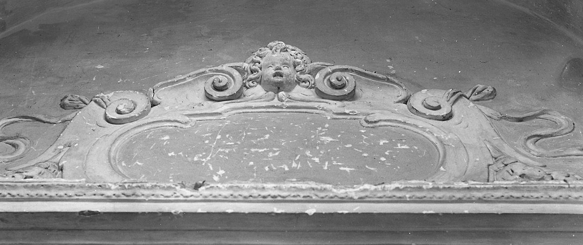 Cherubino e motivi decorativi a volute attorno a cartiglio (decorazione plastica) - ambito parmense (ultimo quarto sec. XVII)