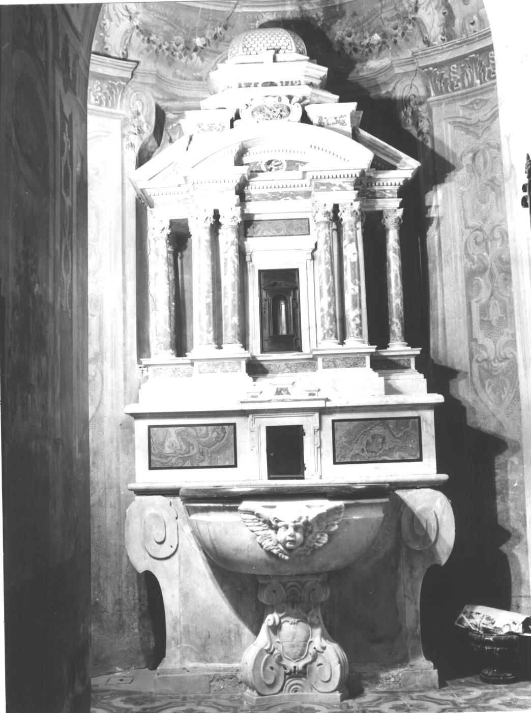 motivo decorativo a volute/ testa alata (fonte battesimale, elemento d'insieme) - bottega ligure (secc. XVI/ XVII)