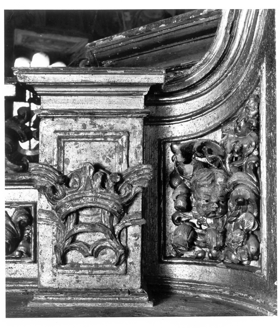 motivo decorativo con testina angelica e corona con palme (decorazione a intaglio, elemento d'insieme) di Del Piaz Giovanni Battista (prima metà sec. XVIII)