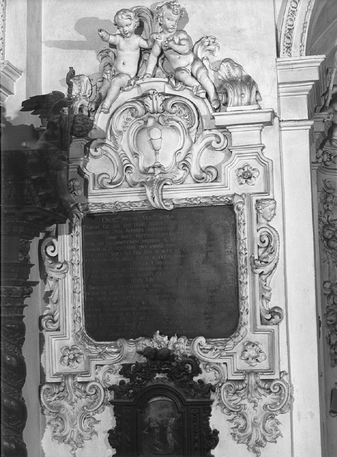Calice con ostia, due putti, due cariatidi fitomorfe, ricci, volute (lapide commemorativa, opera isolata) di Sala Giovanni Angelo (ultimo quarto sec. XVII)