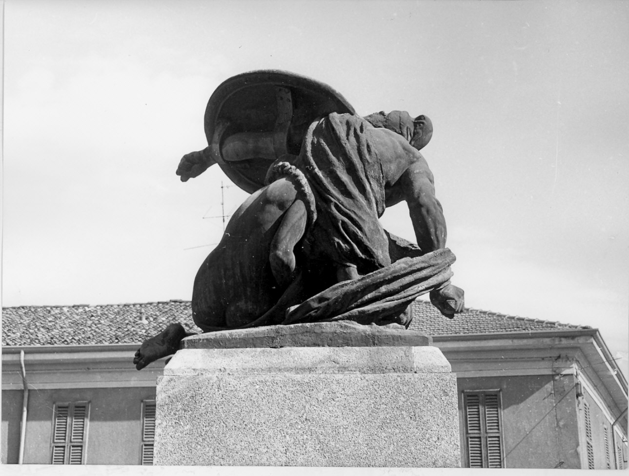 guerriero in atto di proteggere una madre con un bambino (monumento, opera isolata) di Bazzini Cesare (sec. XX)