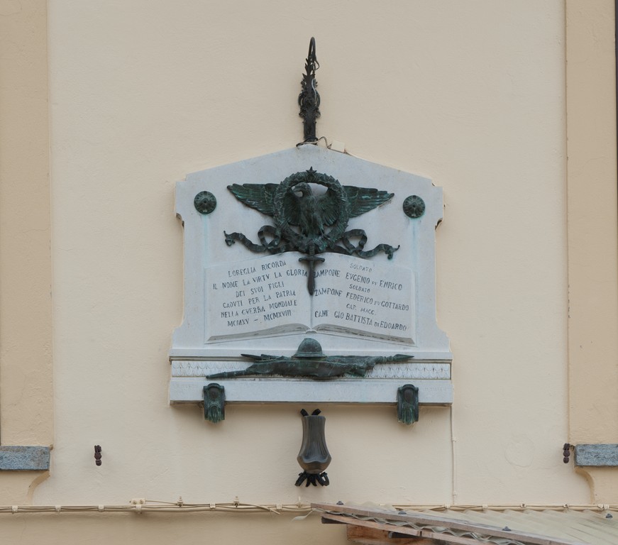 allegoria della Vittoria come aquila, tropaion in relazione alle armi (lapide commemorativa ai caduti) di Ubezio Alfredo B, Maffioli V. M (primo quarto sec. XX)