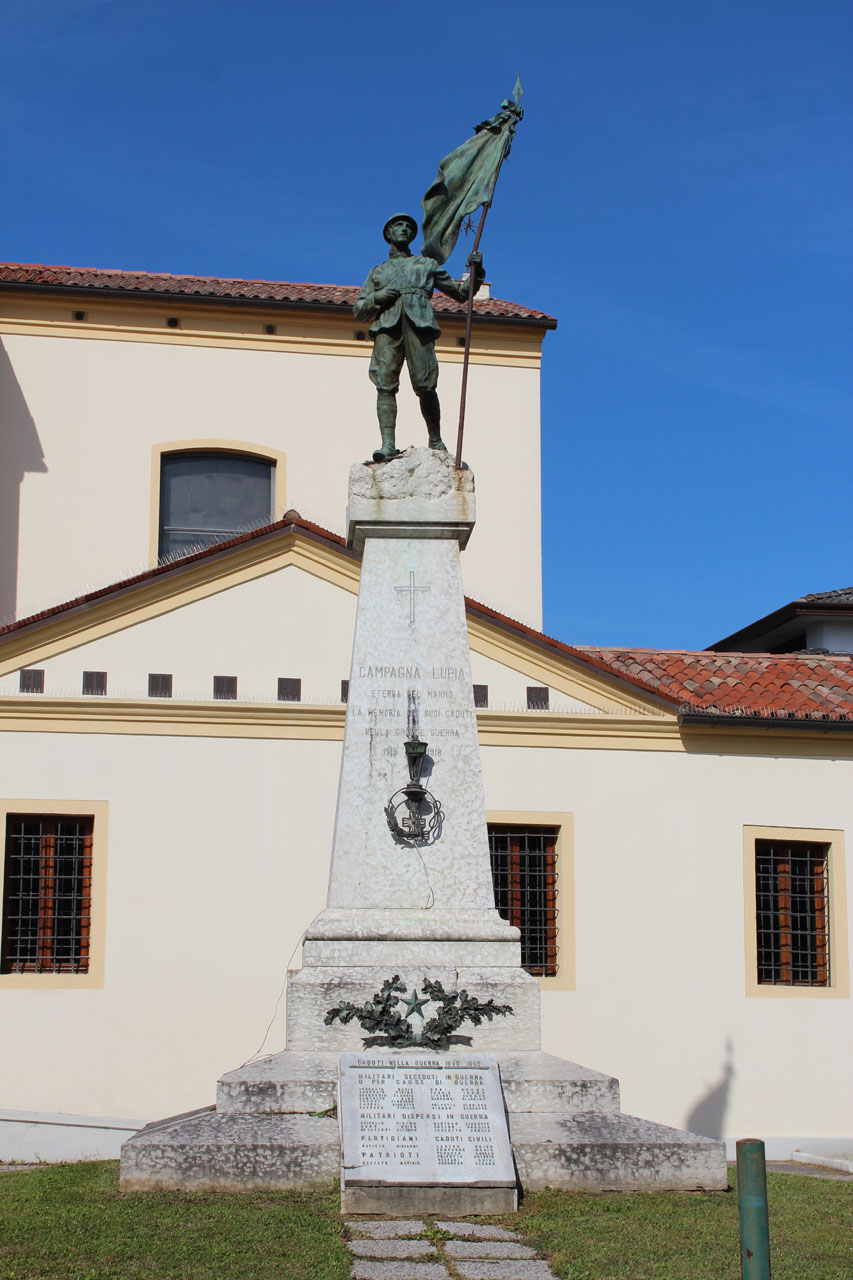 figura di soldato che porta la bandiera monumento ai caduti ad obel