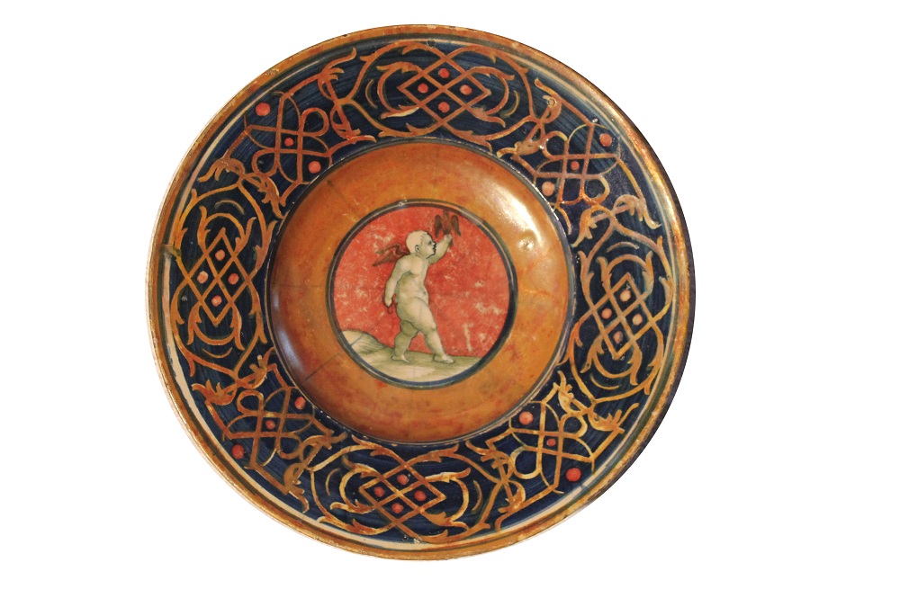 trofei d'armi e Cupido legato a un albero (piatto) - manifattura di Casteldurante (XVI)