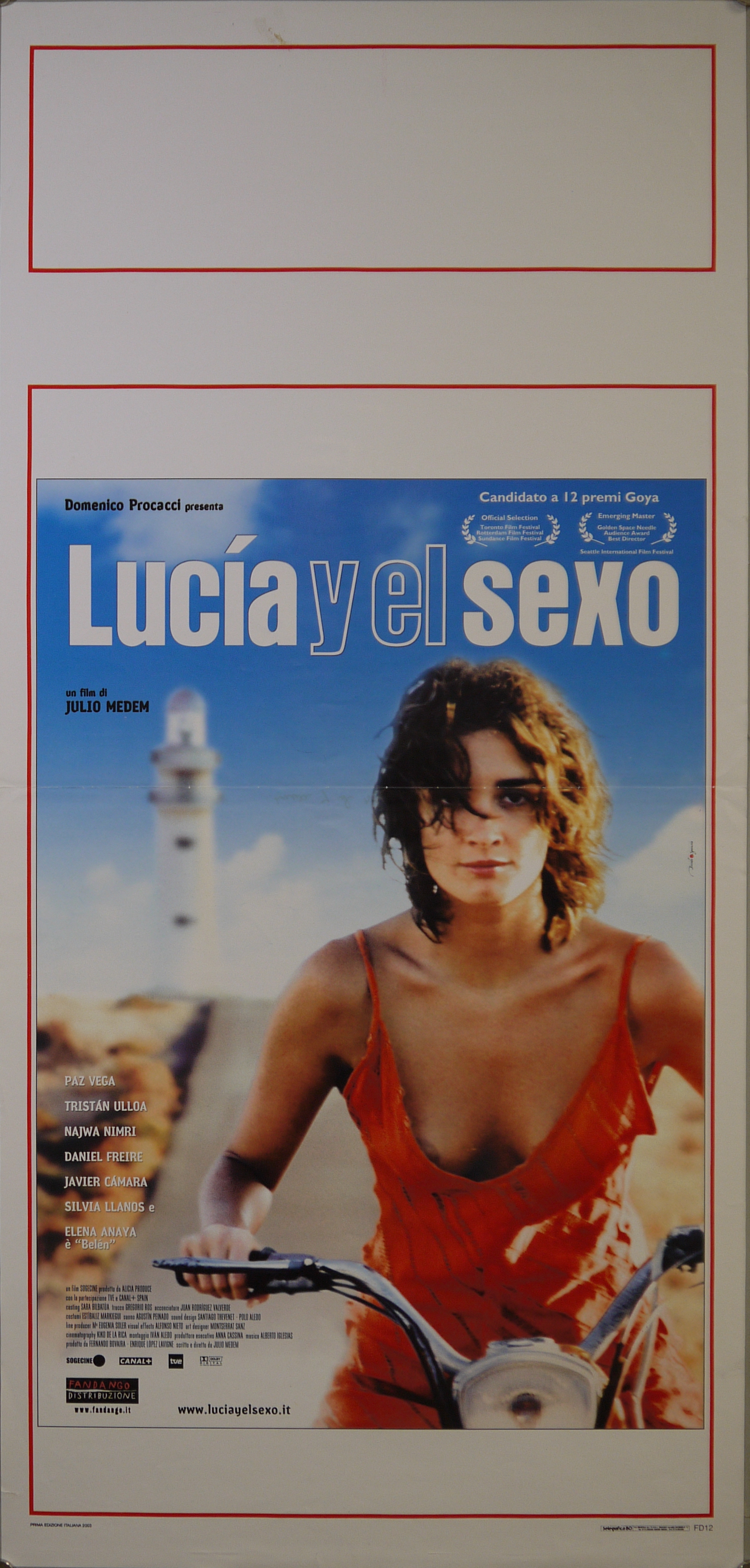 Luci (Paz Vega) si allontana in motorino lungo la strada che conduce a un faro (locandina) di Brivido & Sganascia - ambito spagnolo (inizio XXI)