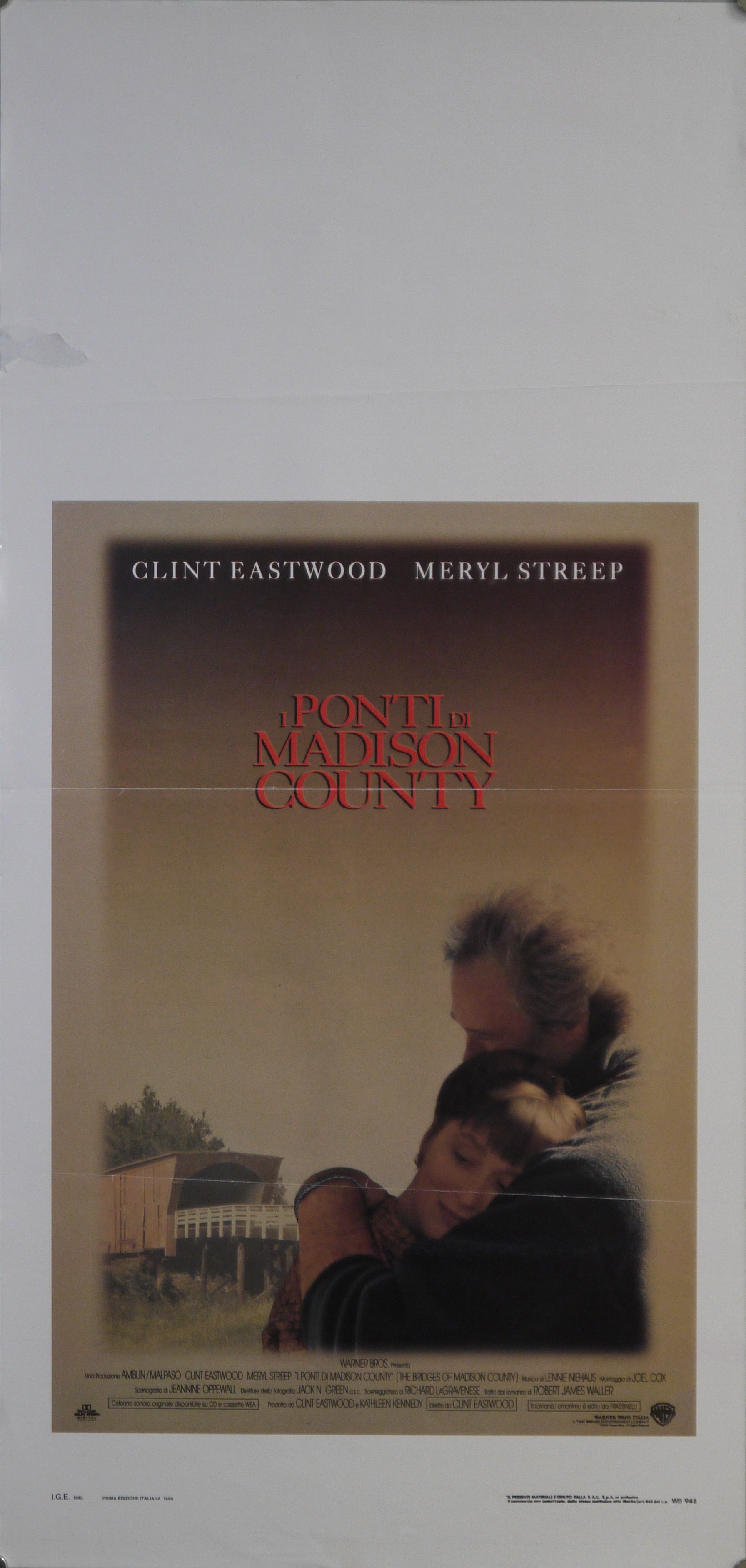 Abbraccio tra Robert Kincaid (Clint Eastwood) e Francesca Johnson (Meryl Streep) sullo sfondo del ponte di Roseman nella contea di Madison (locandina) - ambito americano (fine XX)