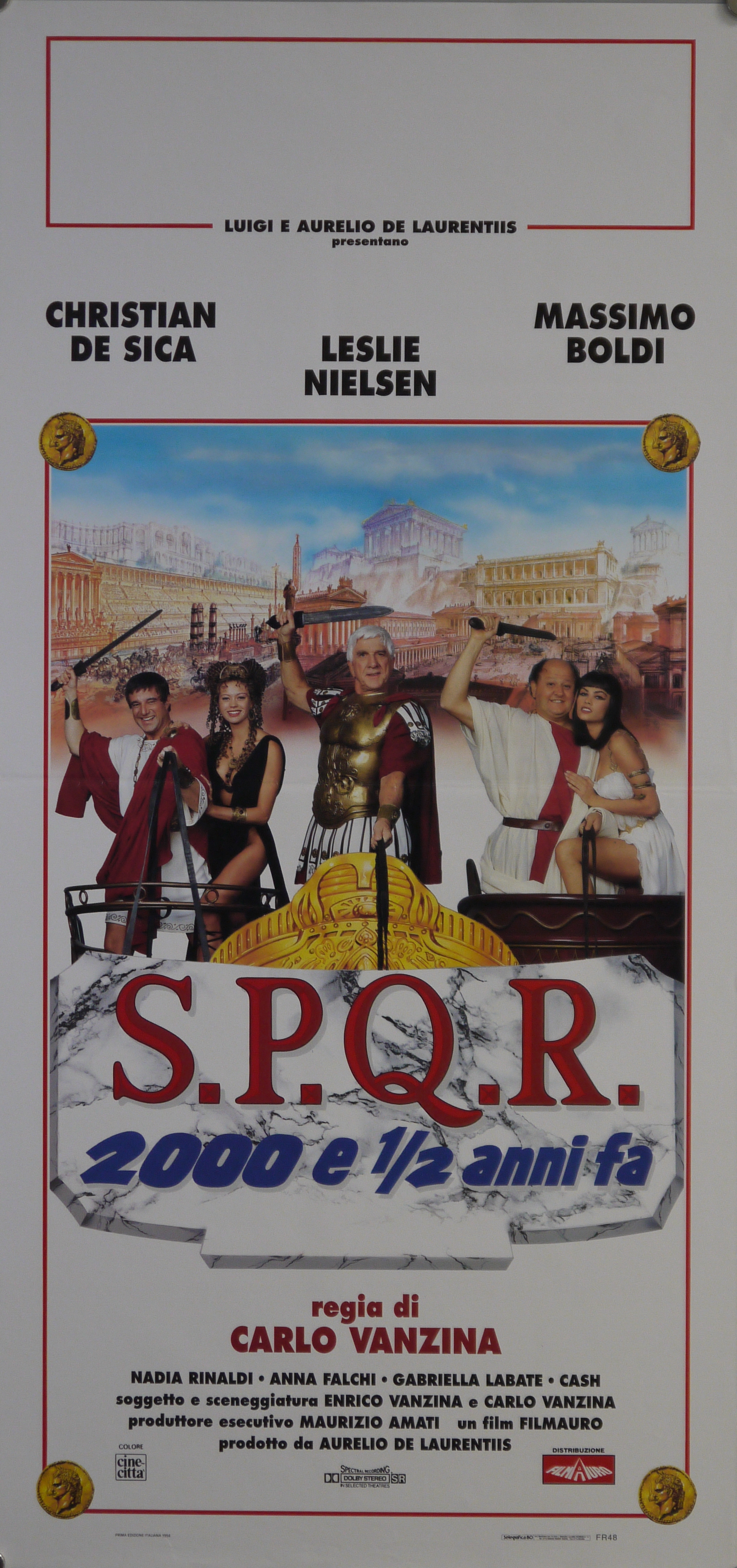 Sullo sfondo di una fantasiosa ricostruzione di Roma antica, a bordo di carri, Lucio Cinico (Leslie Nielsen), Cesare Atticus (Christian De Sica) e Poppea (Anna Falchi), Antonio Servilio (Massimo Boldi) e Iside (Cash Casia) (locandina) - ambito italiano (fine XX)