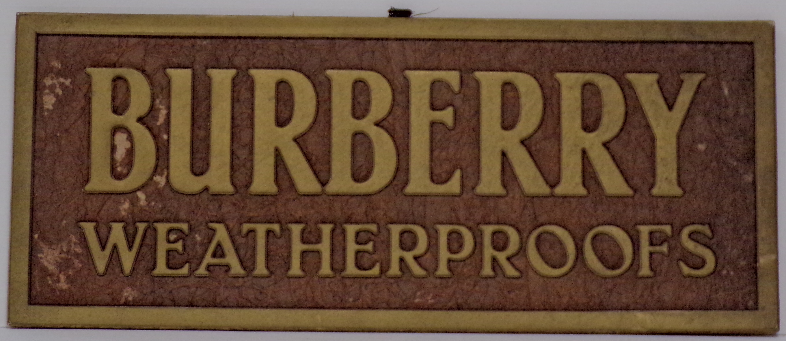 Burberry weatherproofs, Iscrizione dorata su fondo bruno (Cartello - da vetrina, opera isolata) - ambito inglese (metà XX)