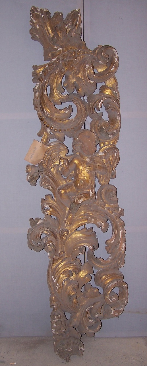 Cherubino seduto tra elementi decorativi derivati da forme vegetali e geometriche (cornice, frammento) - bottega Italia meridionale (fine/ metà XVII/XVIII)