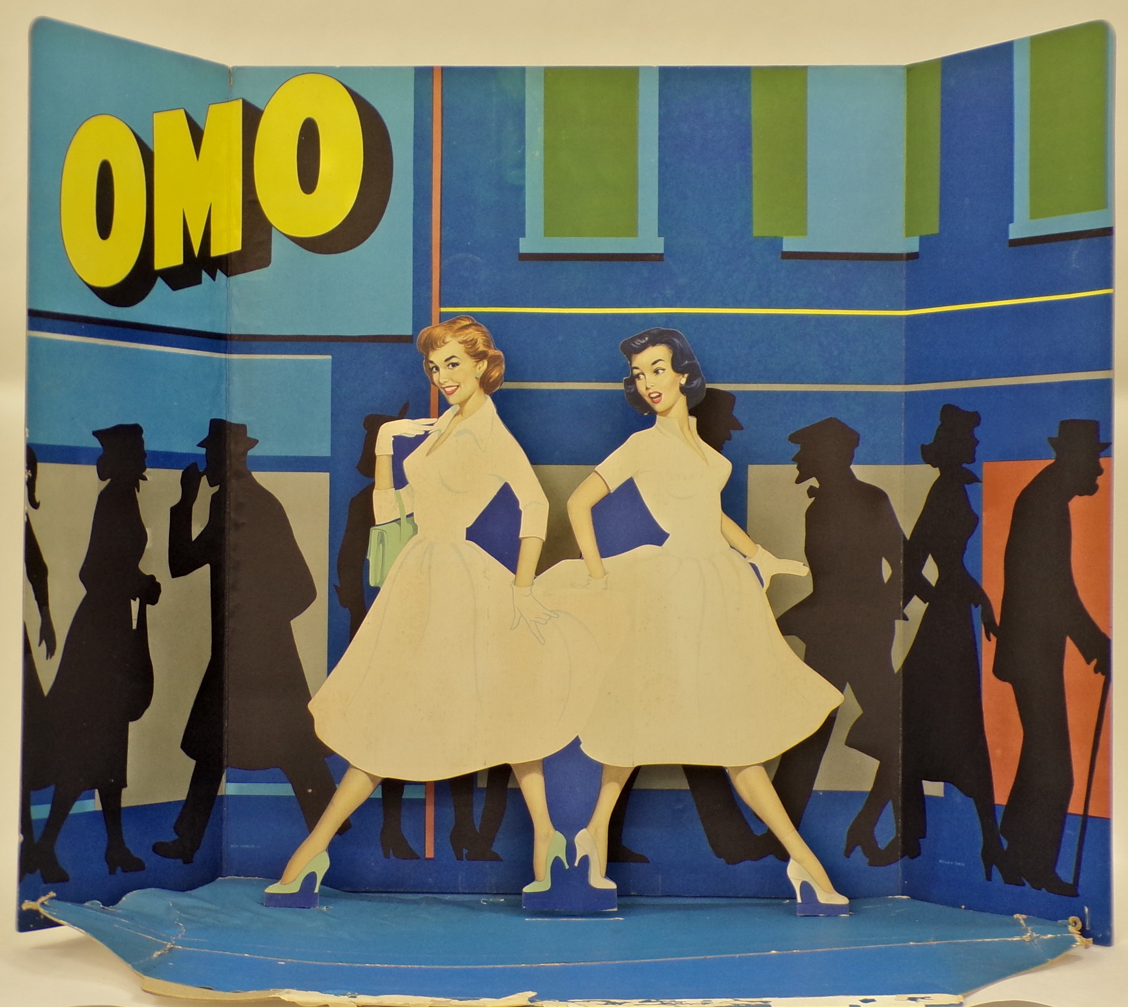 Omo, strada di grande città affollata di passanti, una ragazza rimane stupita dal bianco dell'abito di una passante (Cartello - da vetrina, opera isolata) - ambito milanese (metà XX)