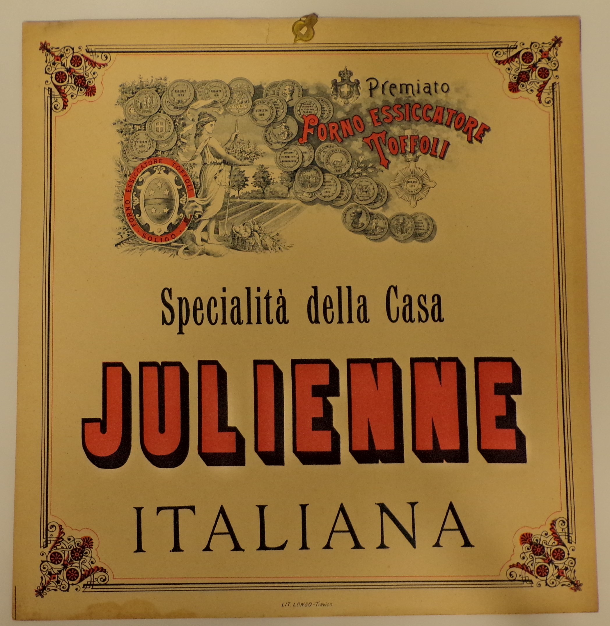 Premiato forno essiccatore Toffoli. Specialità della Casa Julienne, Presso un campo agricolo, presso un rastrello e un falcetto, donna abbigliata all'antica con badile, cesto di fiori in mano e cesto i frutta e verdura a terra. Attorno, innumerevoli medadglie e motivi vegetali (locandina) - ambito trevigiano (primo quarto XX)