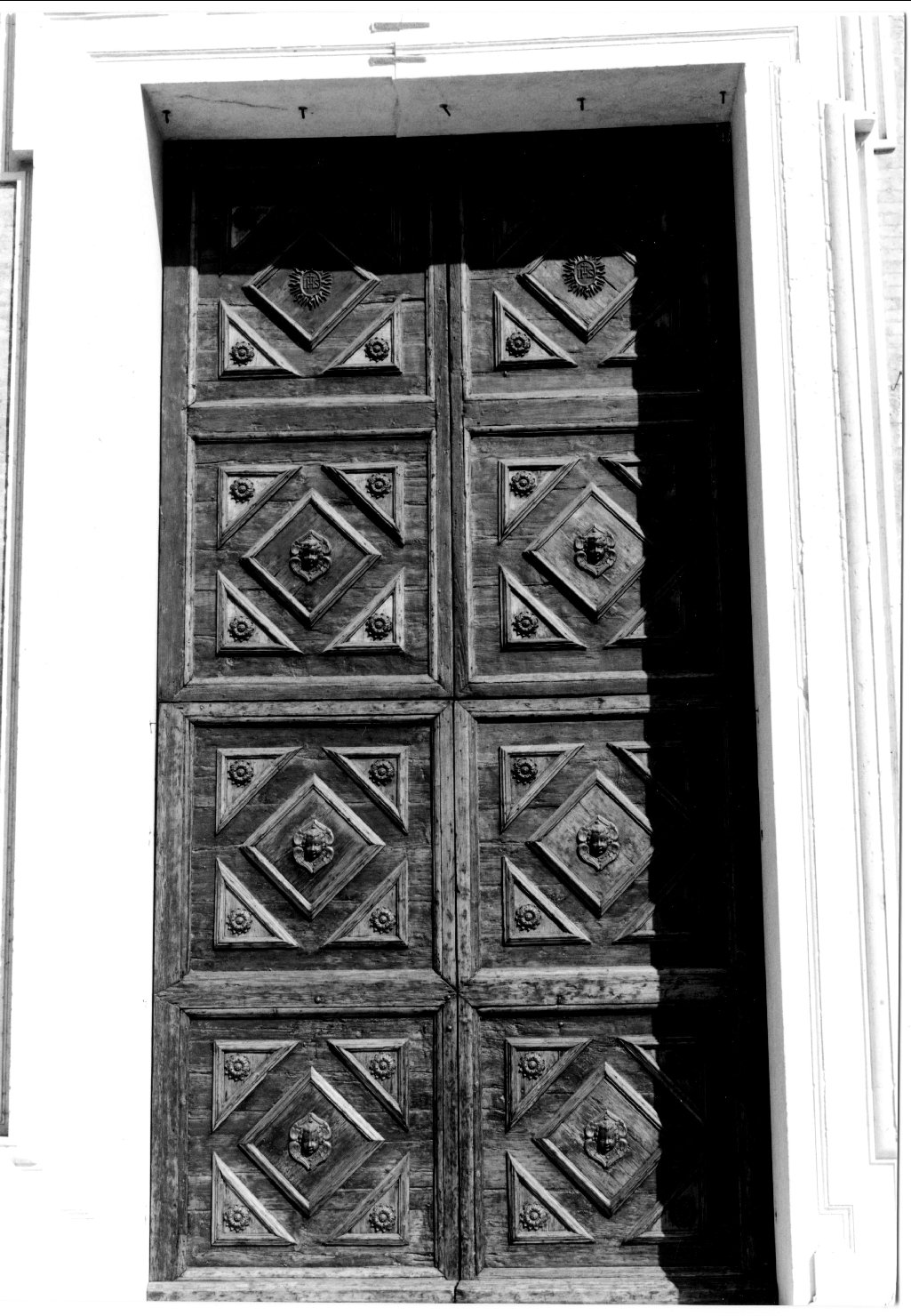 motivi decorativi geometrici; rosette; teste di putto; simboli cristologici (porta) - manifattura ferrarese (sec. XVI)
